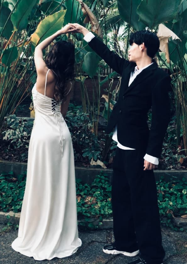 He spins her under his arm in the garden, her gown catching the light